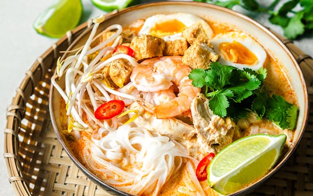 Singaporean seafood laksa with prawns, noodles, and lime.