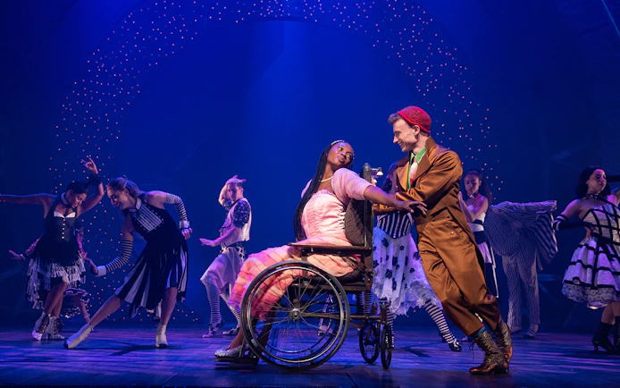 Performers dancing on stage during a scene from the musical Wicked.