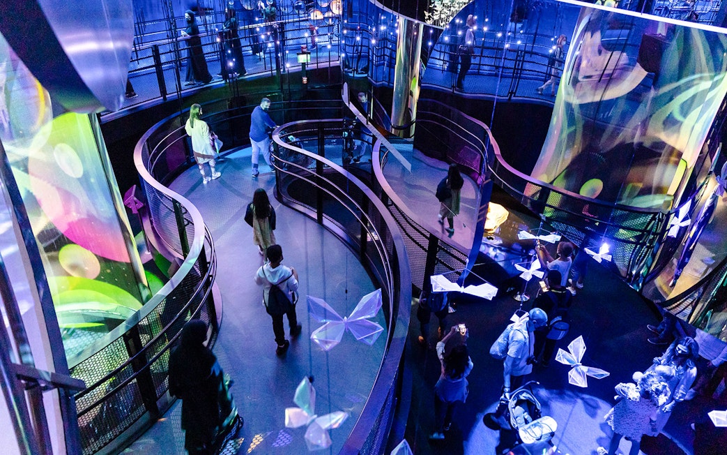 Tourists walking through illuminated exhibit at Expo City Dubai.