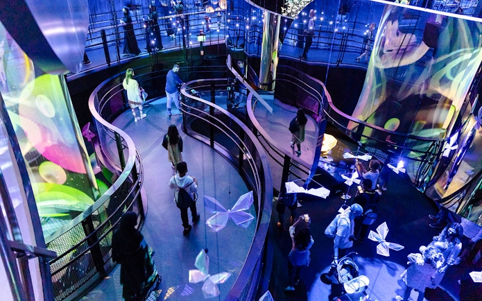 Tourists walking through illuminated exhibit at Expo City Dubai.