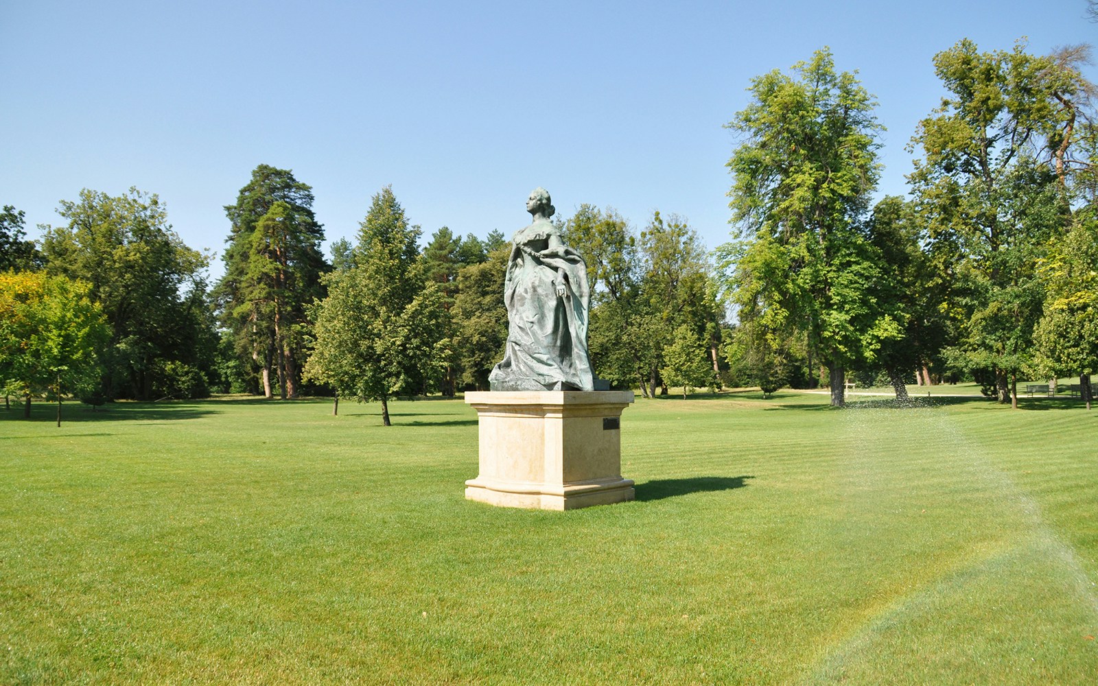 Statue in the gardens of Gödöllő Royal Palace, Hungary, surrounded by trees.