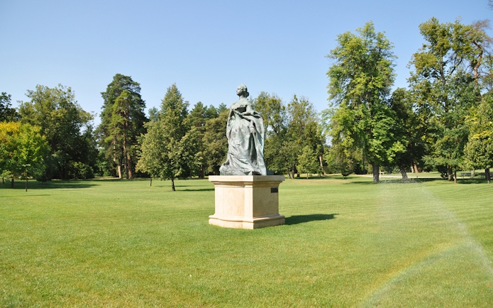 Statue in the gardens of Gödöllő Royal Palace, Hungary, surrounded by trees.
