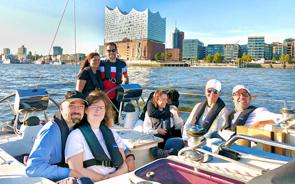 Group enjoying a sailing tour in the Port of Hamburg with Elbphilharmonie in the background.