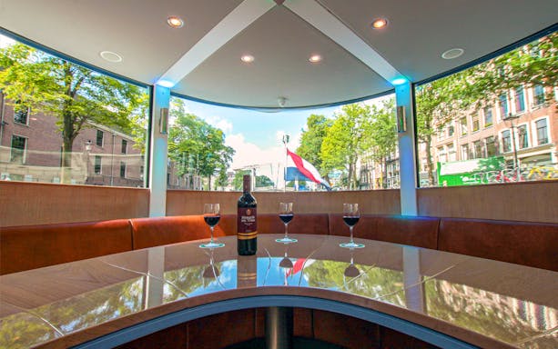VIP Canal Cruise on Stan Huygens with wine glasses and Dutch flag in Amsterdam.