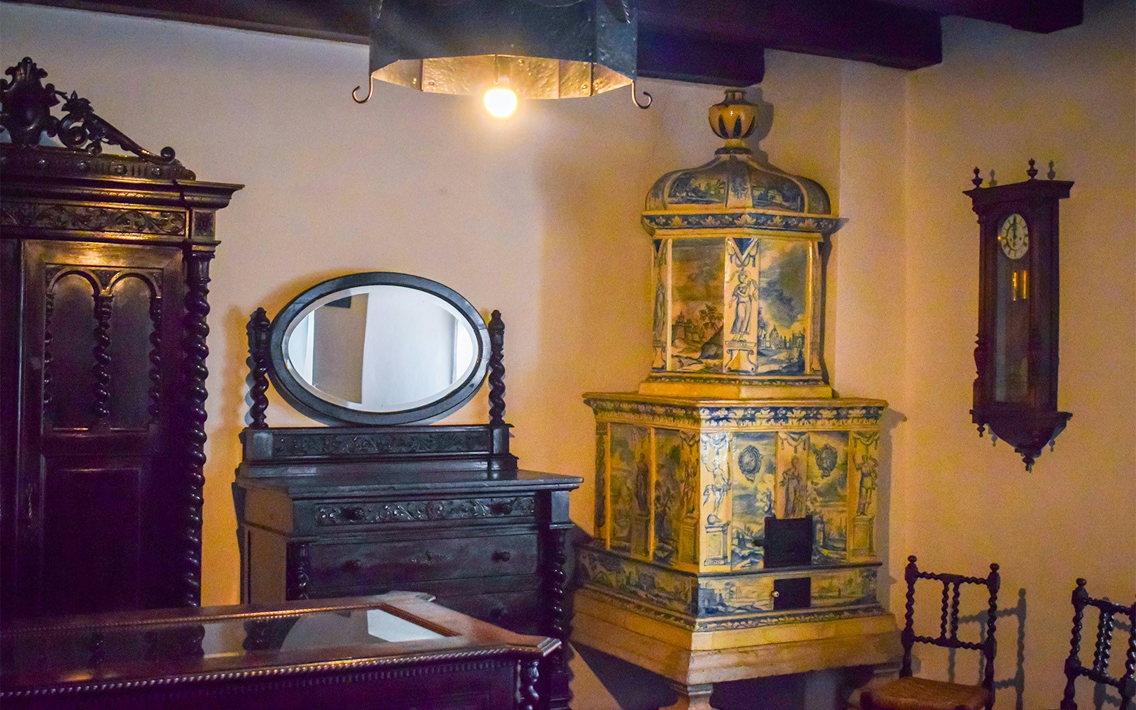 Antique furniture and ornate ceramic stove inside Bran Castle, Romania.