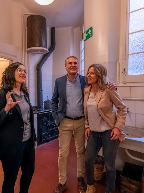 Tourist with guide exploring kitchen in Casa Mila, Barcelona.