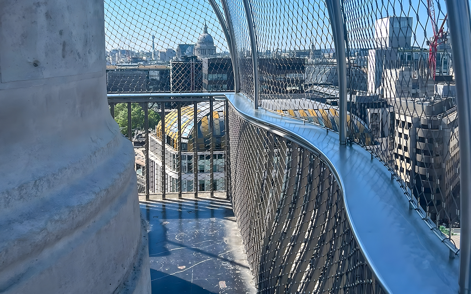 View from the top of the Monument to the Great Fire of London, overlooking city buildings.