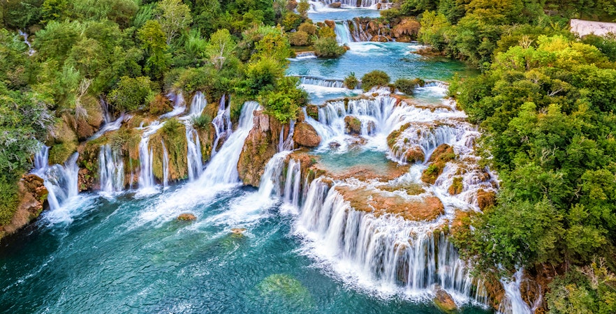Waterfalls cascading over lush greenery in Krka National Park, Croatia, highlighting the natural beauty of the tours.