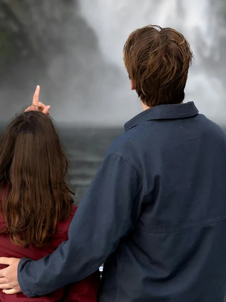 Couple admiring waterfalls on Milford Sound cruise, Queenstown tour.