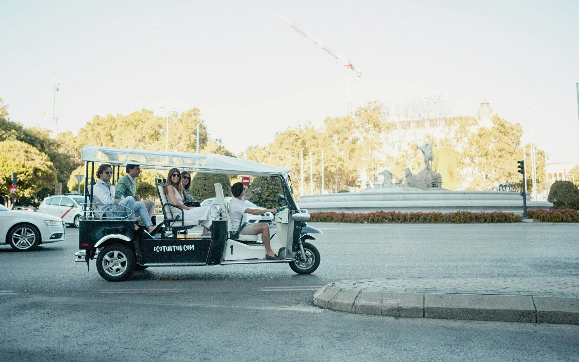 Tourists on an electric tuk-tuk near Cibeles Fountain in Madrid.