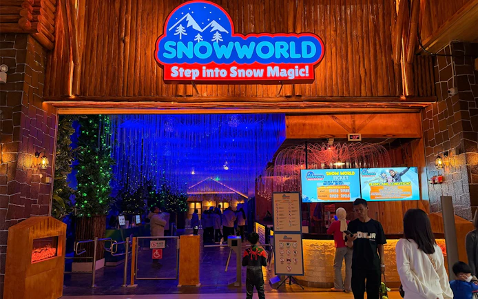 Entrance to Genting Highlands Snow World Theme Park with illuminated sign and ticket counter.
