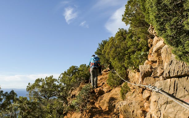 Trekking path along rocky coastline from Masua to Cala Domestica, Sardinia.