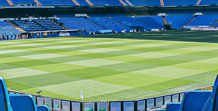 Bernabeu Stadium in Madrid with visitors exploring the iconic football field and seating areas.