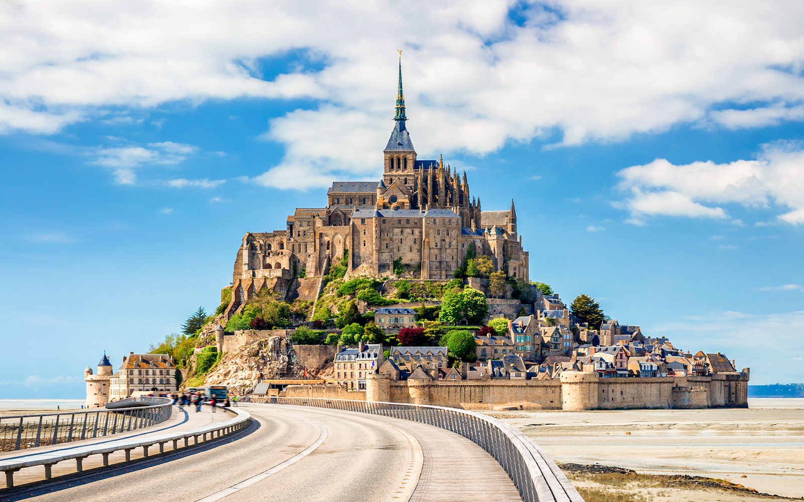 Mont Saint-Michel Abbey with tourists exploring the historic architecture in Normandy, France.
