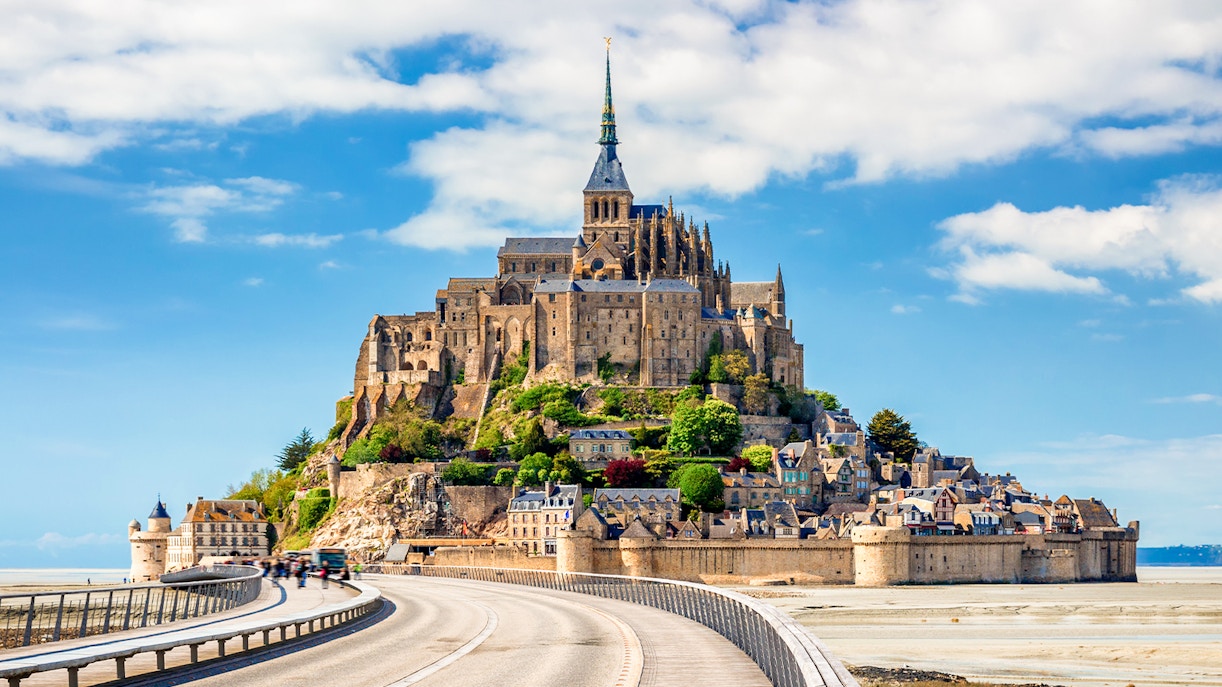Mont Saint-Michel Abbey with tourists exploring the historic architecture in Normandy, France.