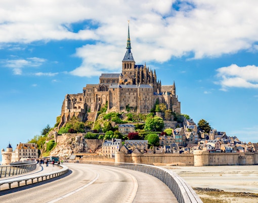 Mont Saint-Michel Abbey on tidal island with connecting bridge, Normandy, France.