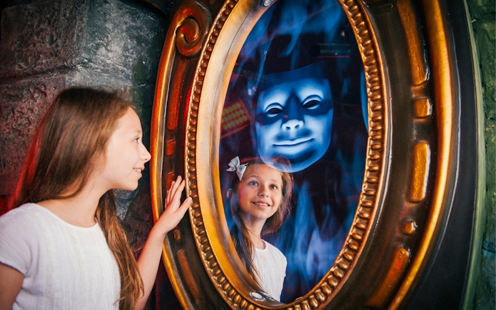 Child interacting with magic mirror at Shrek’s Adventure! London.