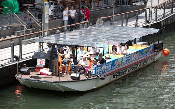 Dotonbori Wonder Cruise boat with passengers on a canal in Osaka, Japan.