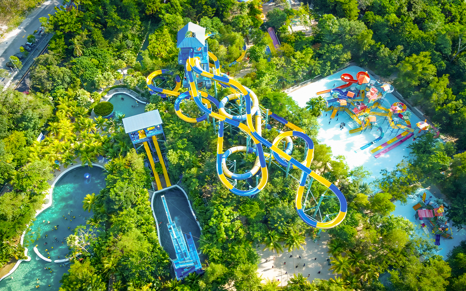 Aerial view of water slides and pools at Escape Penang water park surrounded by lush greenery.