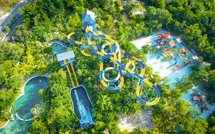 Aerial view of water slides and pools at Escape Penang water park surrounded by lush greenery.