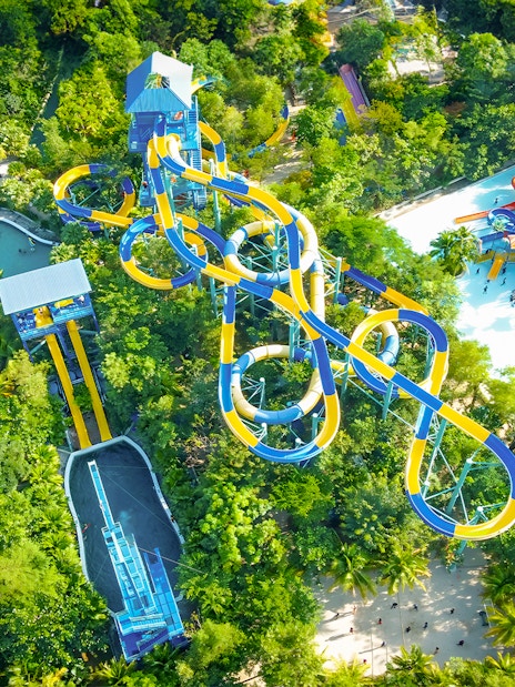 Aerial view of water slides and pools at Escape Penang water park surrounded by lush greenery.