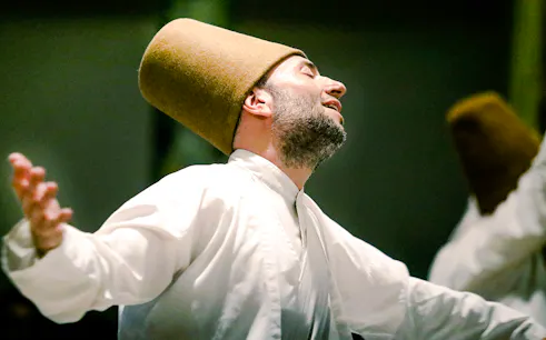 Whirling Dervish performing in traditional attire during a ceremony in Istanbul.