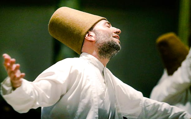 Whirling Dervish performing in traditional attire during a ceremony in Istanbul.
