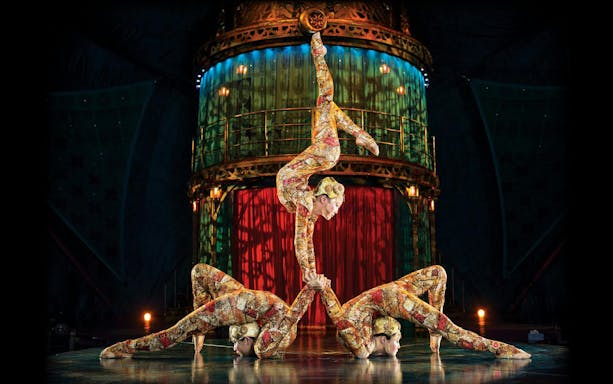 Acrobats performing a balancing act in Kooza stage show.