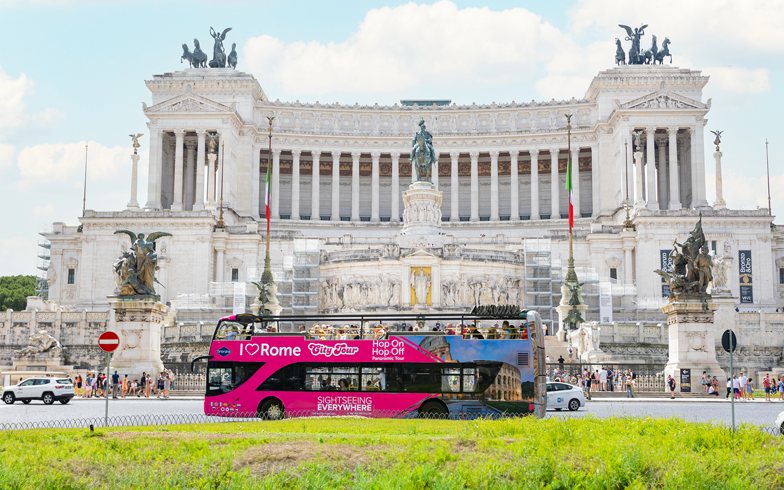 Hop-on hop-off tour bus in front of the Altare della Patria in Rome.