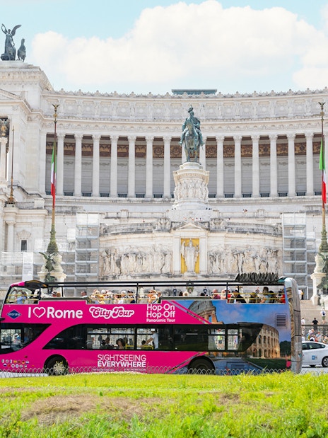 Hop-on hop-off tour bus in front of the Altare della Patria in Rome.
