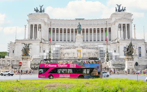 Hop-on hop-off tour bus in front of the Altare della Patria in Rome.