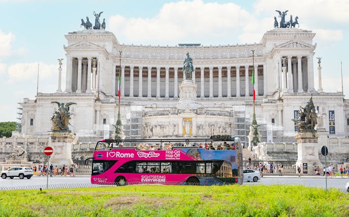 Hop-on hop-off tour bus in front of the Altare della Patria in Rome.