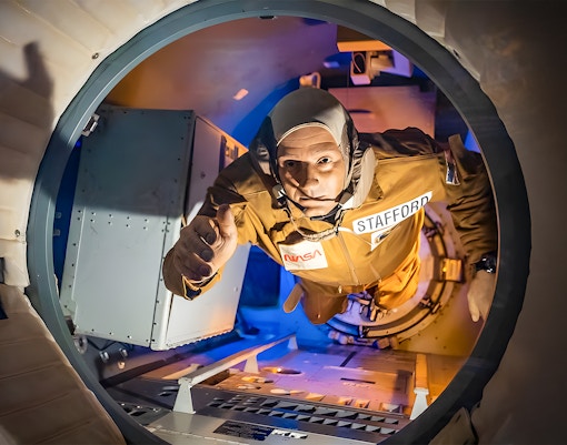 A wax figurine of Stafford reaching his hand out of the rocket at Houston Space Center