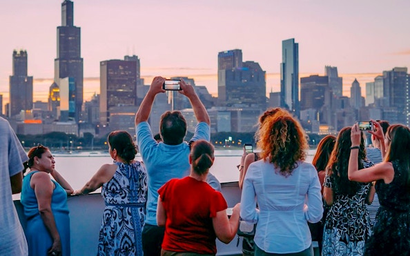 Guests taking photos of Chicago skyline on Odyssey Lake Michigan Dinner Cruise.