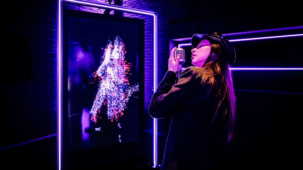 Tourist engaging with digital art at Audiovisual Experience in Amaze Amsterdam.