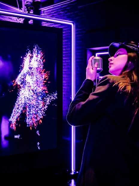 Tourist engaging with digital art at Audiovisual Experience in Amaze Amsterdam.