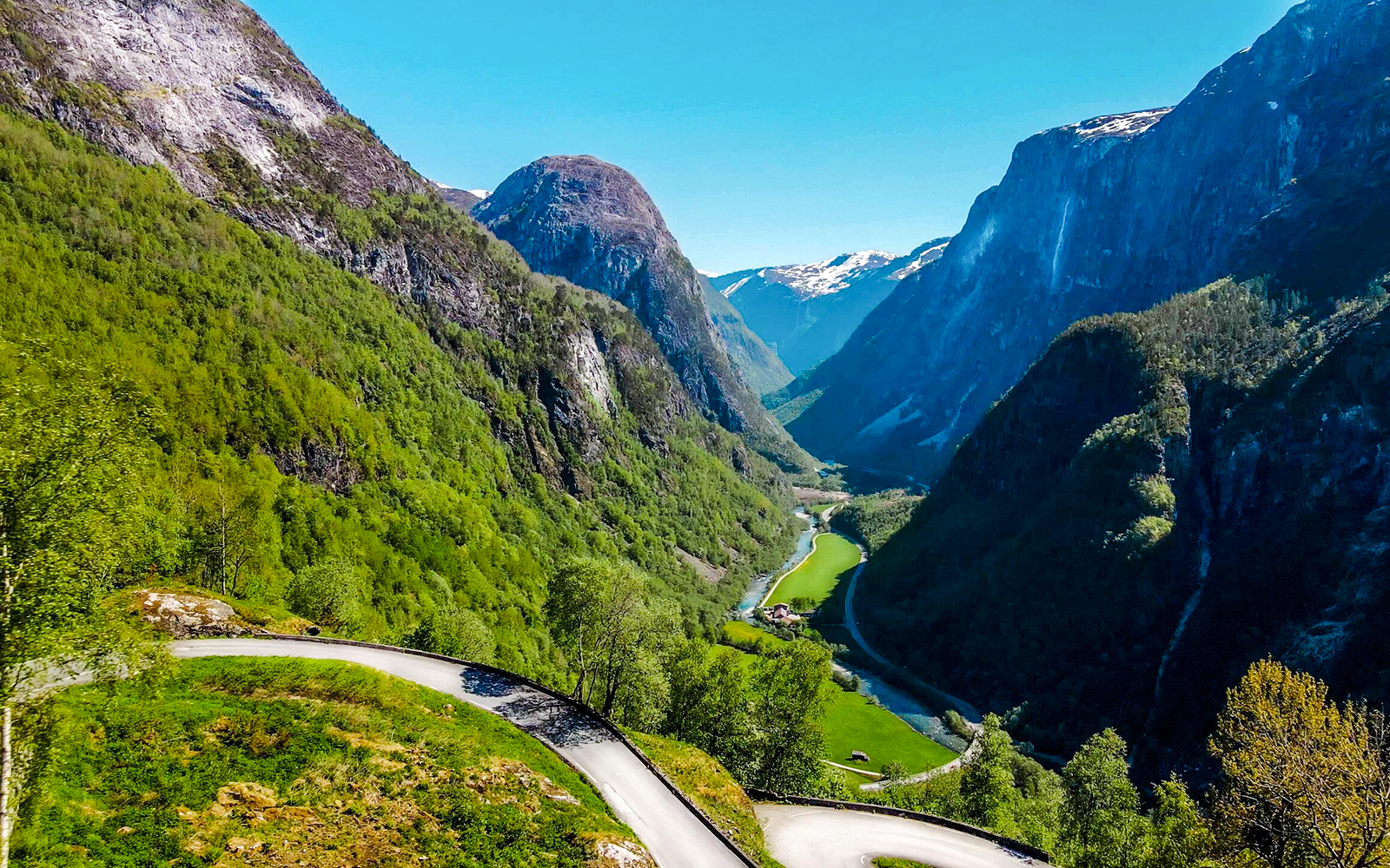 Winding road through Nærøydalen valley with lush green mountains, Western Norway.