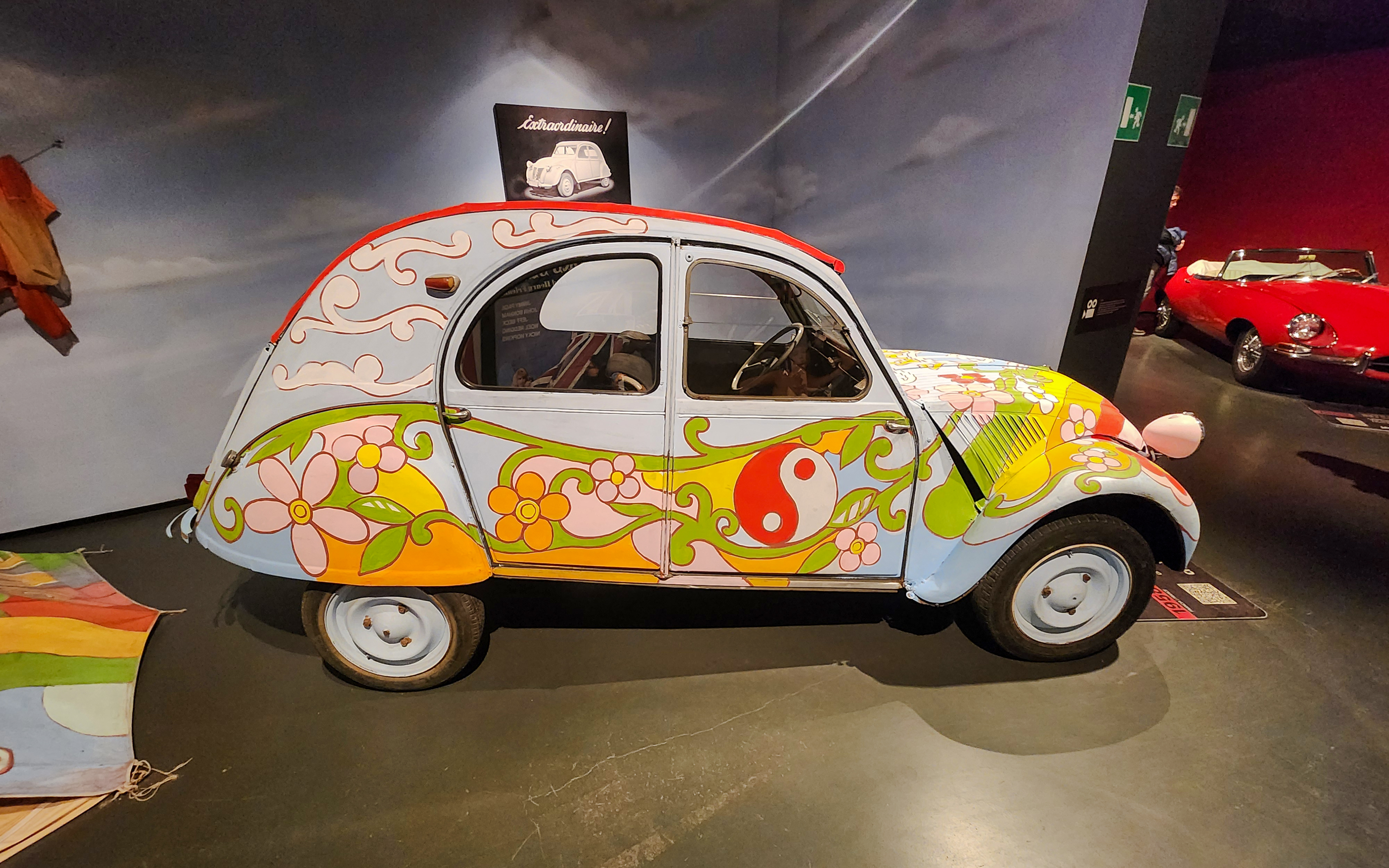 Citroën 2CV with colorful floral design at National Automobile Museum, Turin, Italy.