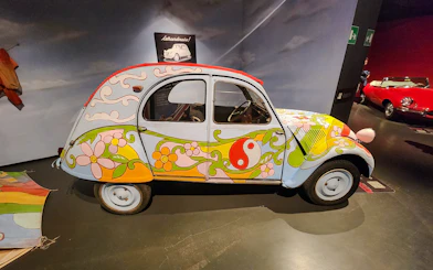 Citroën 2CV with colorful floral design at National Automobile Museum, Turin, Italy.