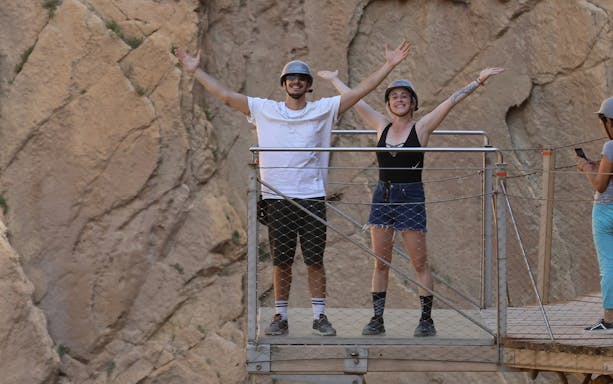 Visitors on a walkway at Caminito del Rey, Malaga, enjoying the scenic cliff views.