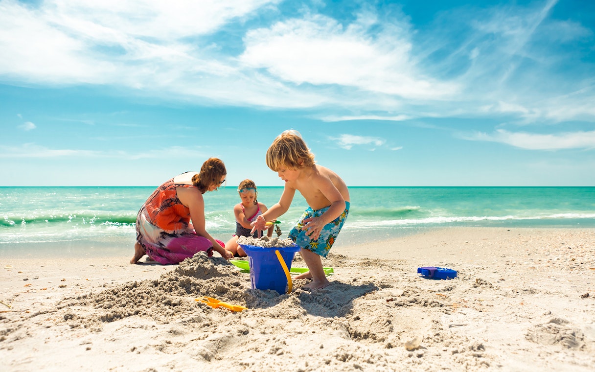 Children playing in sand at Clearwater Beach during The Sea Screamer Boat Ride tour.