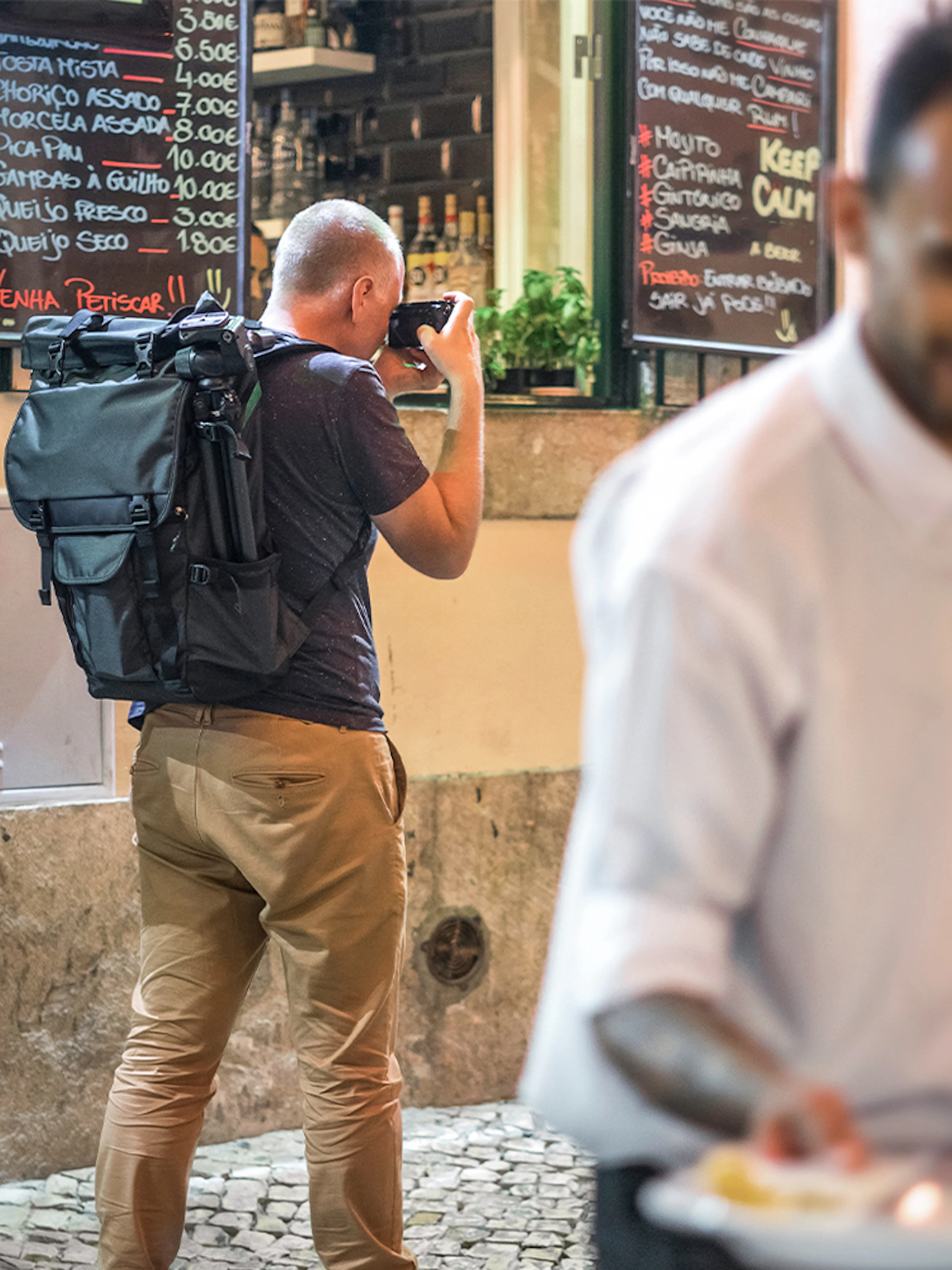 Tourists exploring Alfama's narrow streets with local dining options.
