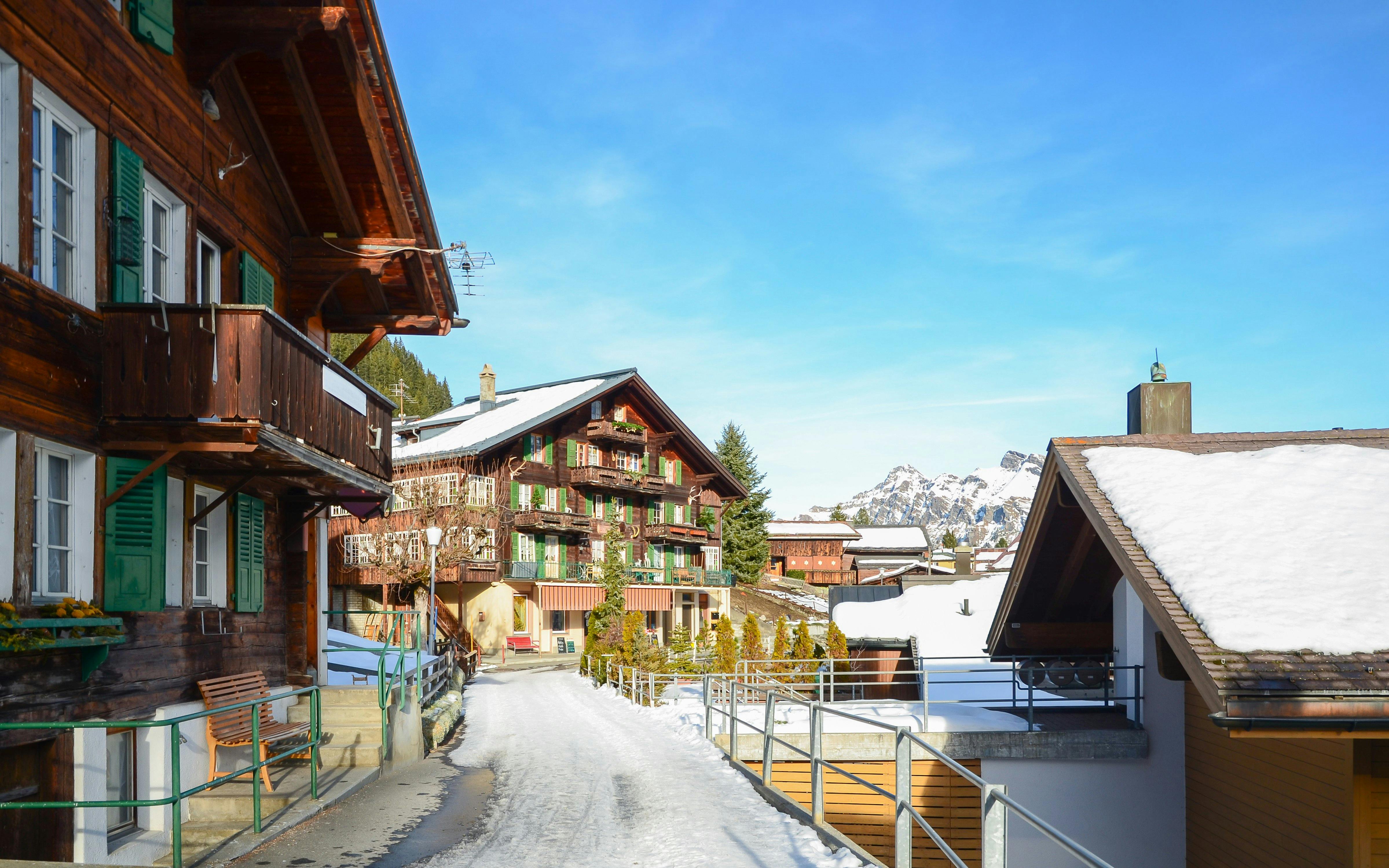 Chalets in Interlaken with snow-covered roofs and distant mountain view.