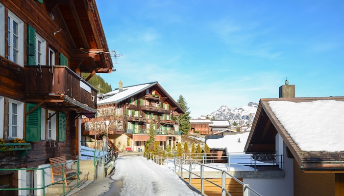 Chalets in Interlaken with snow-covered roofs and distant mountain view.