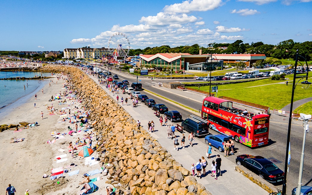 Double-decker bus on Galway Hop-On-Hop-Off Tour passing a busy beach.