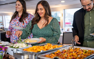 Guests serving themselves dinner on the San Diego Signature Dinner Cruise buffet.