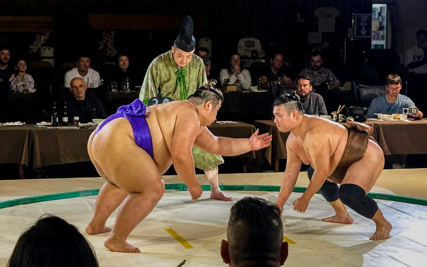 Sumo wrestlers competing in an arena during the Sumo Show & Samurai Night Experience.