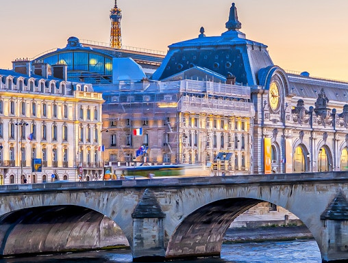 Orsay Museum and Seine River with Eiffel Tower in Paris at sunset.