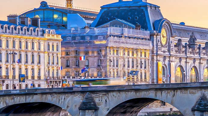 Orsay Museum and Seine River with Eiffel Tower in Paris at sunset.