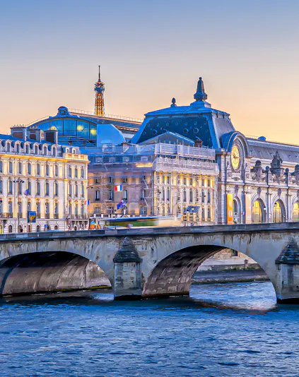 Orsay Museum and Seine River with Eiffel Tower in Paris at sunset.